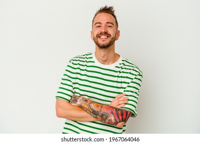 Young tattooed caucasian man isolated on white background who feels confident, crossing arms with determination. - Powered by Shutterstock