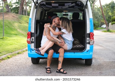 Young Tattooed Couple Smile, Hug And Kiss In The Back Of The Van.