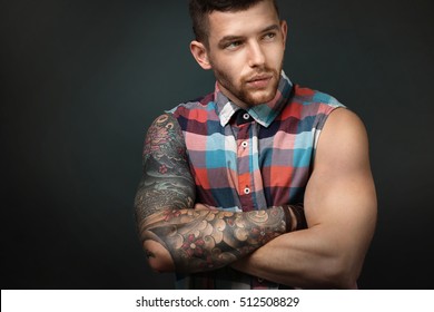 Joven hombre tatuado posando