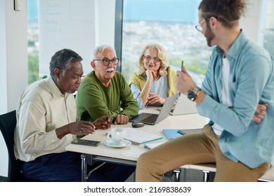 A Young Teacher Asks A Small Group Of Multiracial Senior Students Questions About Digital Marketing In A Classroom.