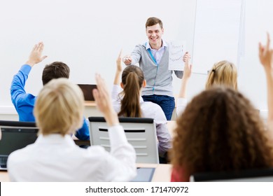 Young Teacher In Classroom Standing In Front Of Class