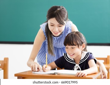 young Teacher helping child with writing lesson