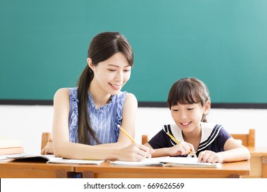 young Teacher helping child with writing lesson