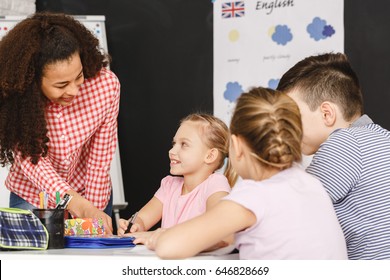 Young Teacher Helping Kids During English Lesson