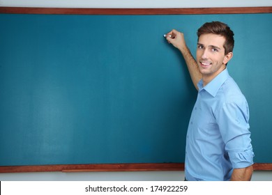 Young Teacher Near Chalkboard In School Classroom