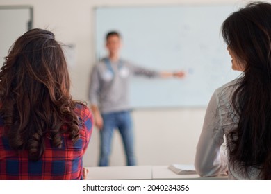 Young Teacher Preparing Students For Standardized Test Using Pen And A Notebook, Preparation For SAT, Preparation For ACT, CLT, Preparation For Math Exam, Standardized Test Preparation