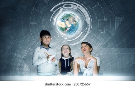 Young teacher and school children examining hologram. Elements of this image are furnished by NASA - Powered by Shutterstock