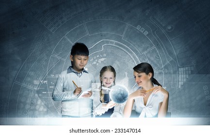 Young teacher and school children examining hologram. Elements of this image are furnished by NASA - Powered by Shutterstock