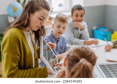 Young teacher with solar panel learning pupils about solar energy. - Powered by Shutterstock