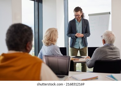 A Young Teacher Teaching A Small Group Of Senior Students In A Classroom.