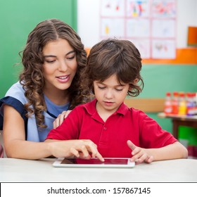 Young teacher teaching students to use digital tablet in classroom - Powered by Shutterstock