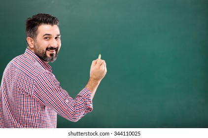 Young Teacher Writing On Blackboard.