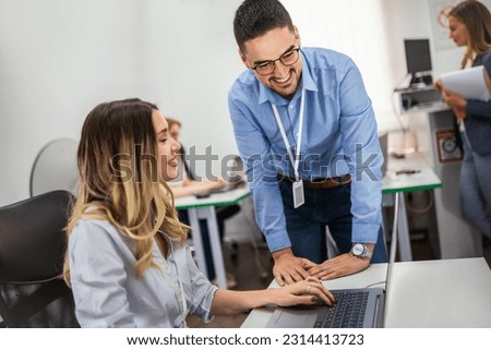 Young teachers teaching young students a programming class in the classroom.