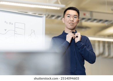 A young teaching instructor is adjusting his lavalier microphone in preparation for a online remote teaching session in front of the camera. - Powered by Shutterstock