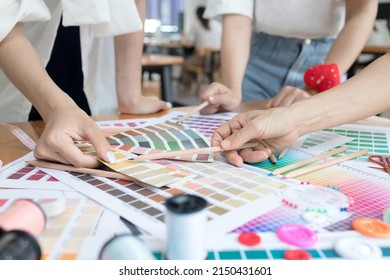 Young team asian designer women working at studio. Fashion designer carefully creating new fashionable styles. Dressmaker makes clothes job
