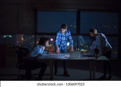 young team of business people in group, architect and engineer on construction site checking documents and business workflow using laptop computer in new startup office at night