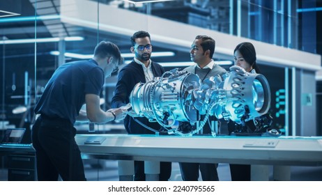 Young Team of Engineers, Project Manager and Machinery Operators Collaborate on a New Type of a Gas Turbine Engine, Standing with Tablet and Laptop Computers in Scientific Technology Lab. High Angle. - Shutterstock ID 2240795565