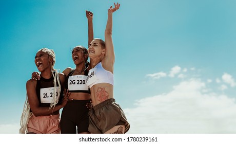 Young Team Of Female Athletes Enjoying Victory. Diverse Group Of Runners Celebrating Success.