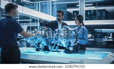 Young Team of Multicultural Engineers Use Blueprints, Tablet and Laptop Computers, Analyze and Discuss How a Modern Electric Turbine Motor Works. High Tech Research Laboratory with Modern Equipment.