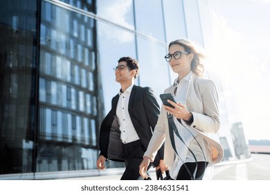 A young team of programmers or financiers in glasses go to the office business meeting a woman and a man people in business clothes smile . - Powered by Shutterstock