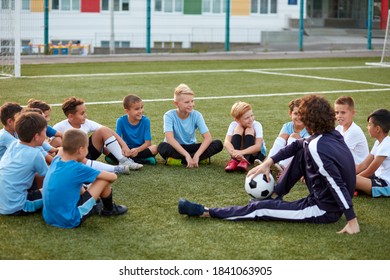 young team of sportive boys take a break during football competition, caucasian children talk, discuss, listen to trainer - Powered by Shutterstock