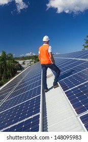 Young technician checking solar panels on factory roof - Shutterstock ID 148095983