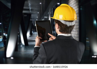 A young technician with a hard hat with digital tablet in hands. - Shutterstock ID 1648115926