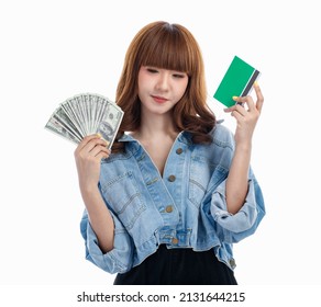 Young Teen Asian Woman Holding American Banknotes That Spread Out In Hand And Holding Bank Account Deposit Passbook, Studio Shot On White Background With Copy Space.