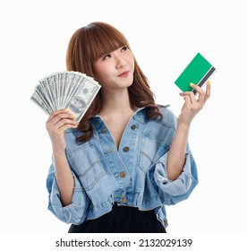 Young Teen Asian Woman Holding American Banknotes That Spread Out In Hand And Holding Bank Account Deposit Passbook, Studio Shot On White Background With Copy Space.