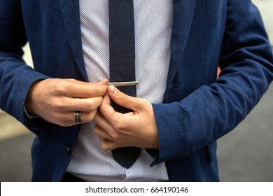 Young Teen Boy Casually Dressed Fixes His Tie Needle