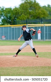 Young Teen Boy On The Pitching Mound During Wind Up.