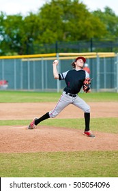 Young Teen Boy On The Pitching Mound During Wind Up.