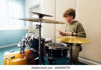 Young teen boy practicing drumming. Drum music school.