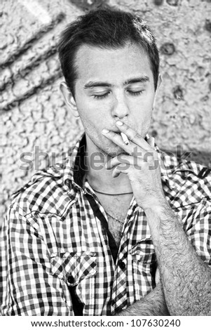 Similar – young guy in a shirt smokes on the street