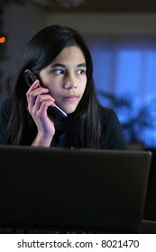 Young Teen Girl Answering Phone At Night With Wary Expression.