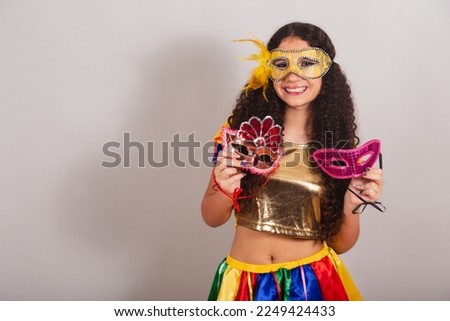 young teen girl, brazilian, with frevo clothes, carnival. holding carnival masks.
