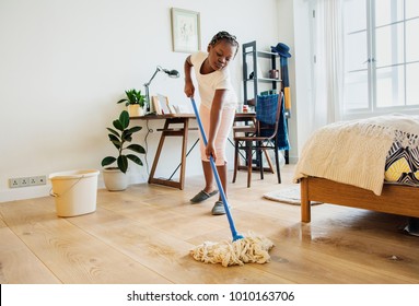 Young Teen Girl Sweeping Up The Floor