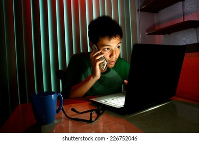 Young Teen Using A Cellphone Or Smartphone In Front Of A Laptop Computer Photo Of A Young Teen Using A Cellphone Or Smartphone In Front Of A Laptop Computer