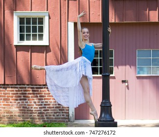 Young teenage ballet dancer balancing on a lightpole.