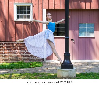 Young teenage ballet dancer balancing on a lightpole.
