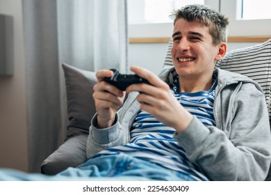 Young teenage boy enjoys playing video games - Shutterstock ID 2254630409