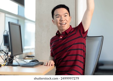 A young teenage college student is raising his hand and asking a question in a computer lab classroom - Powered by Shutterstock