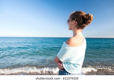 Young teenage fashionable girl resting standing on Mediterranean Sea spectacular seashore. Multicolored summertime outdoors horizontal image with blue cloudless sky background. - Powered by Shutterstock