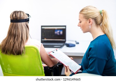 Young Teenage Girl And Child Therapist During EEG Neurofeedback Session. Electroencephalography Concept. 