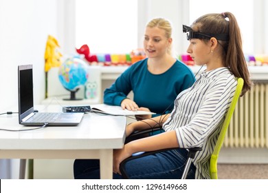 Young Teenage Girl And Child Therapist During EEG Neurofeedback Session. Electroencephalography Concept. 