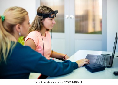 Young Teenage Girl And Child Therapist During EEG Neurofeedback Session. Electroencephalography Concept. 