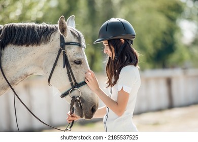 Young Teenage Girl Equestrian Showing Love And Care To Her Favorite Horse. Dressage Outfit