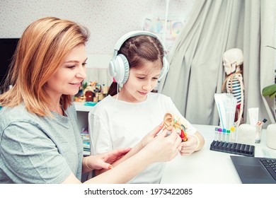 Young Teenage Girl With Mom Studying Human Anatomy At Home. Unusual Hobby. 