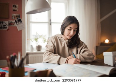 Young teenage girl studying in her room.