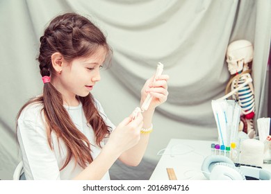 Young Teenage Girl Studying Human Anatomy At Home. She Measures The Bone Of The Arm. Unusual Hobby. 